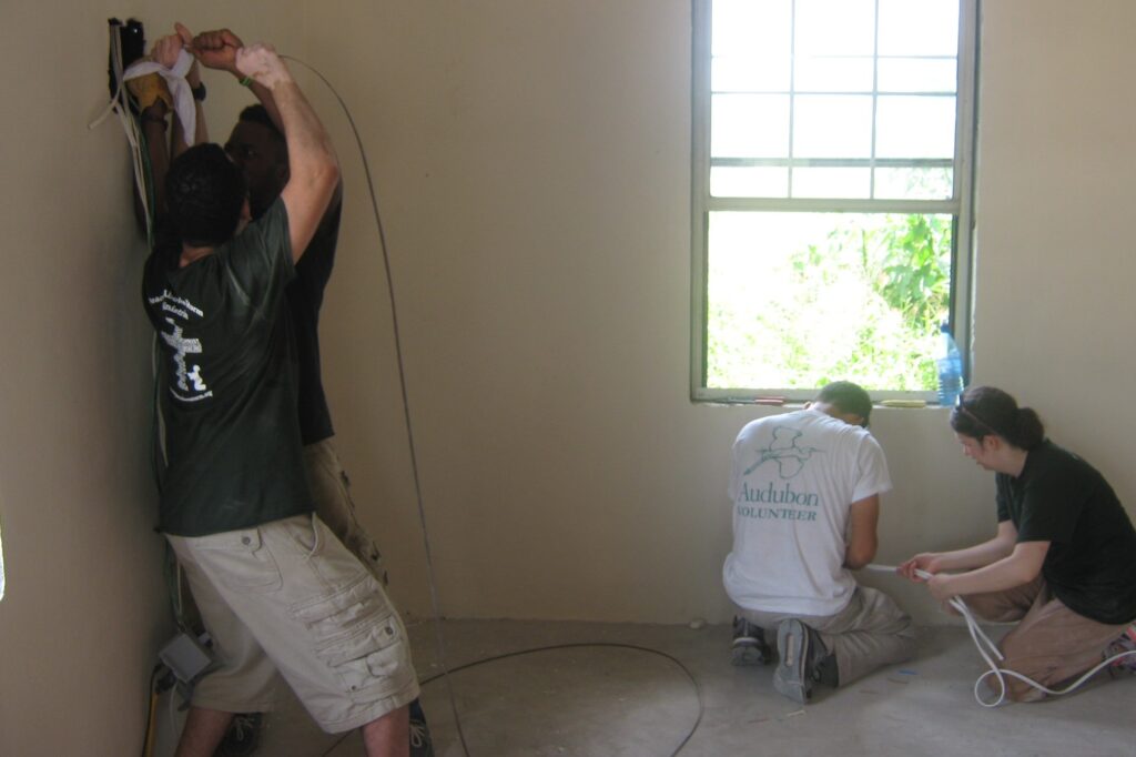 Gavin running wires through the walls for a building project in Belize, 2014.