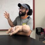 Gavin holding baby CPR manikin.